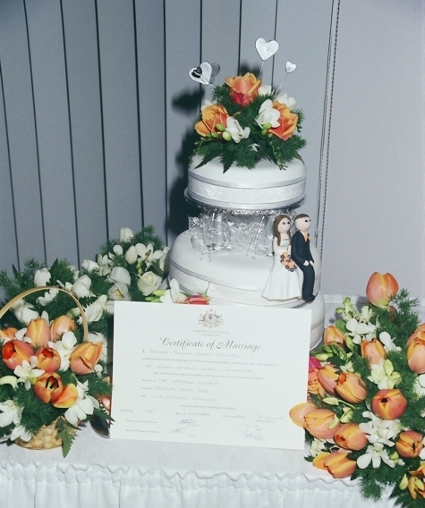 Wedding cake: Setting with bouquets & the certificate.